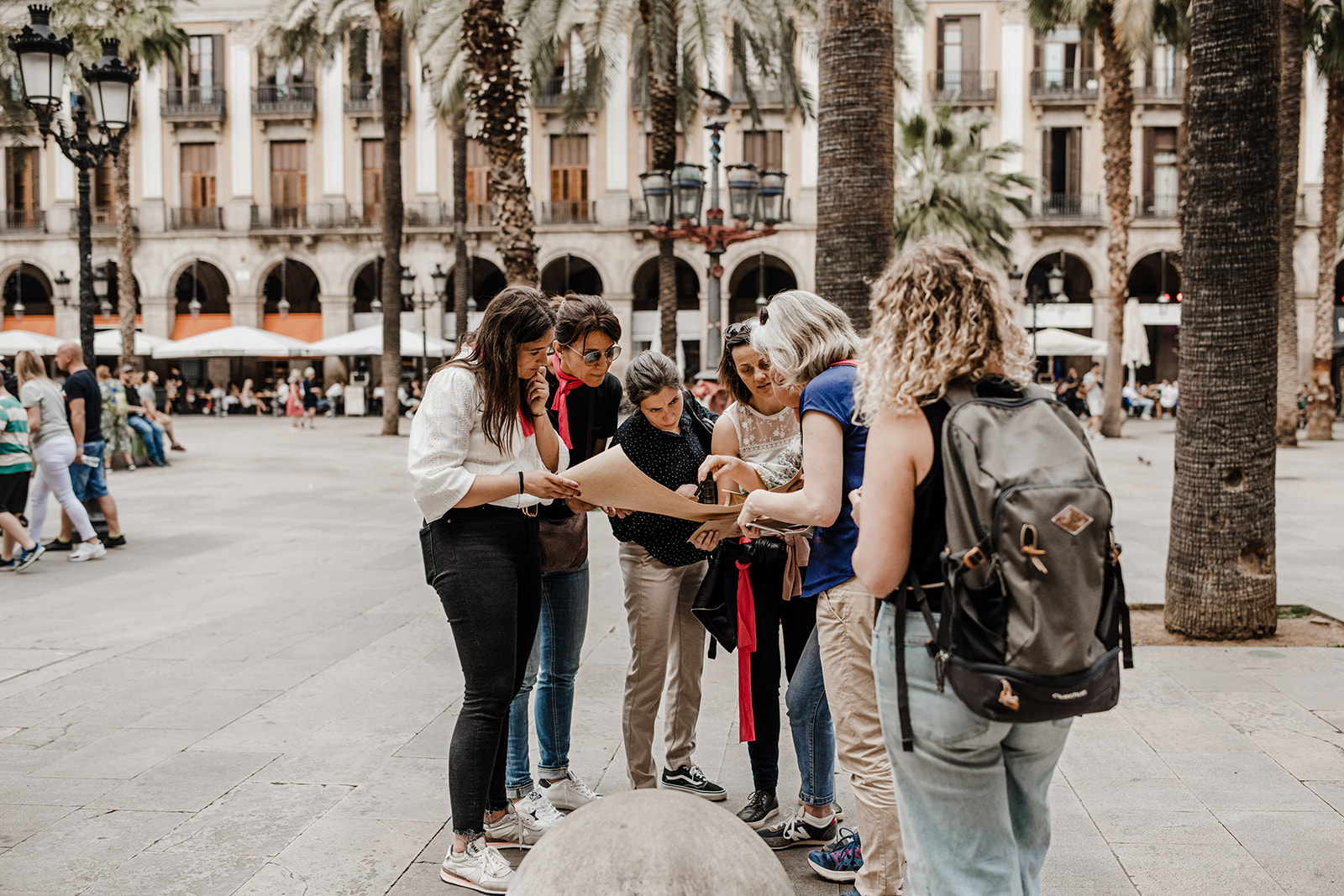 Group of colleagues during city game in Gothic Quarter Barcelona supervised by a private game master from Xventura on Plaza Reial.